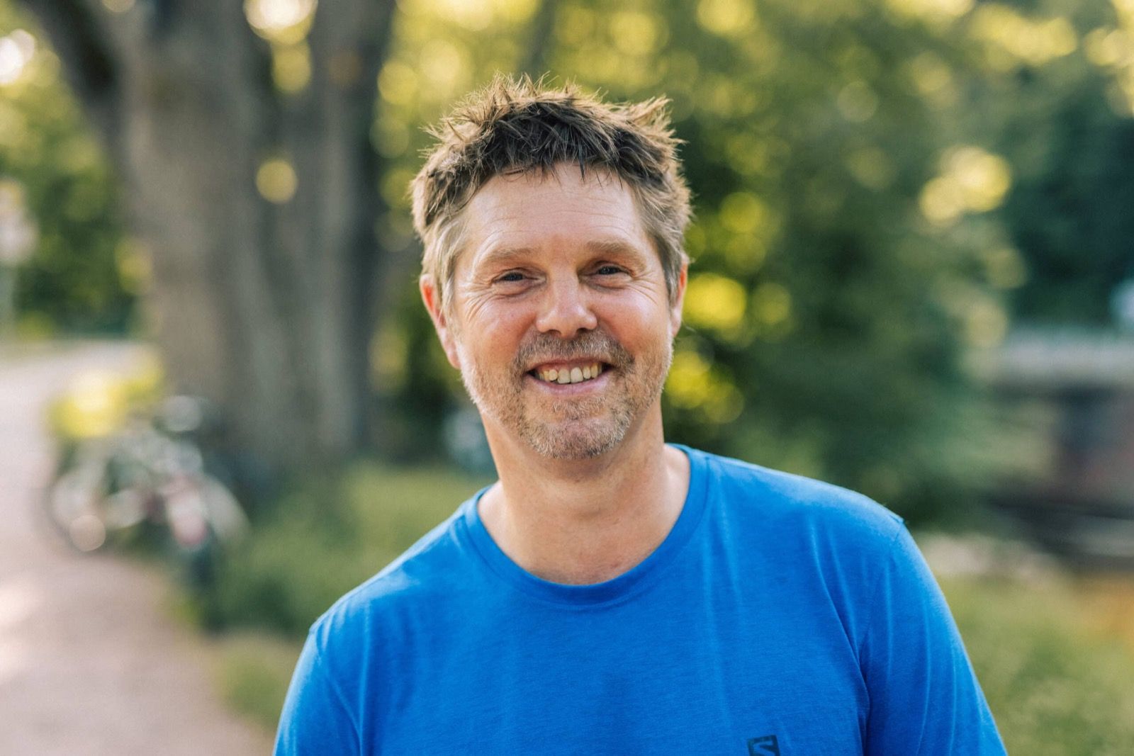 Stephan lacht in die Kamera, im Hintergrund Bäume.